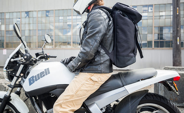 Nik on his Buell Blast motorcycle, helmet and leather jacket on, wearing the Shadow Guide 33 backpack.